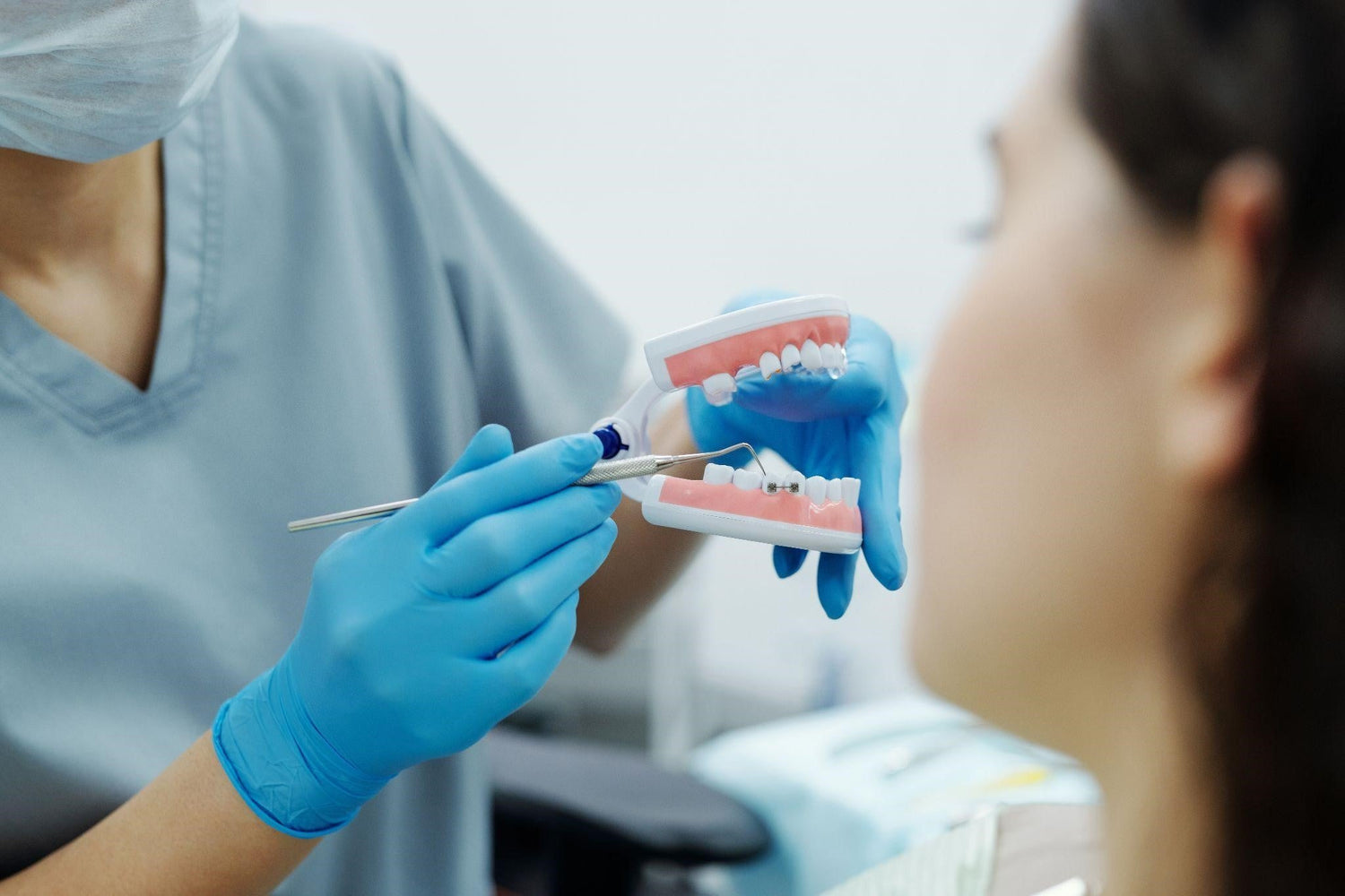 Dentist showing patient how to care for her braces