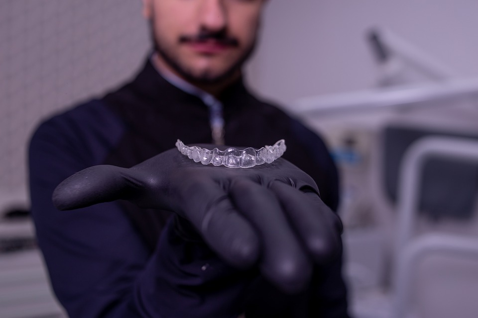 Man holding Invisalign aligner for orthodontic treatment