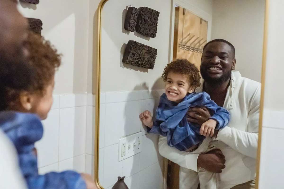 Father and son looking at their teeth in a mirror