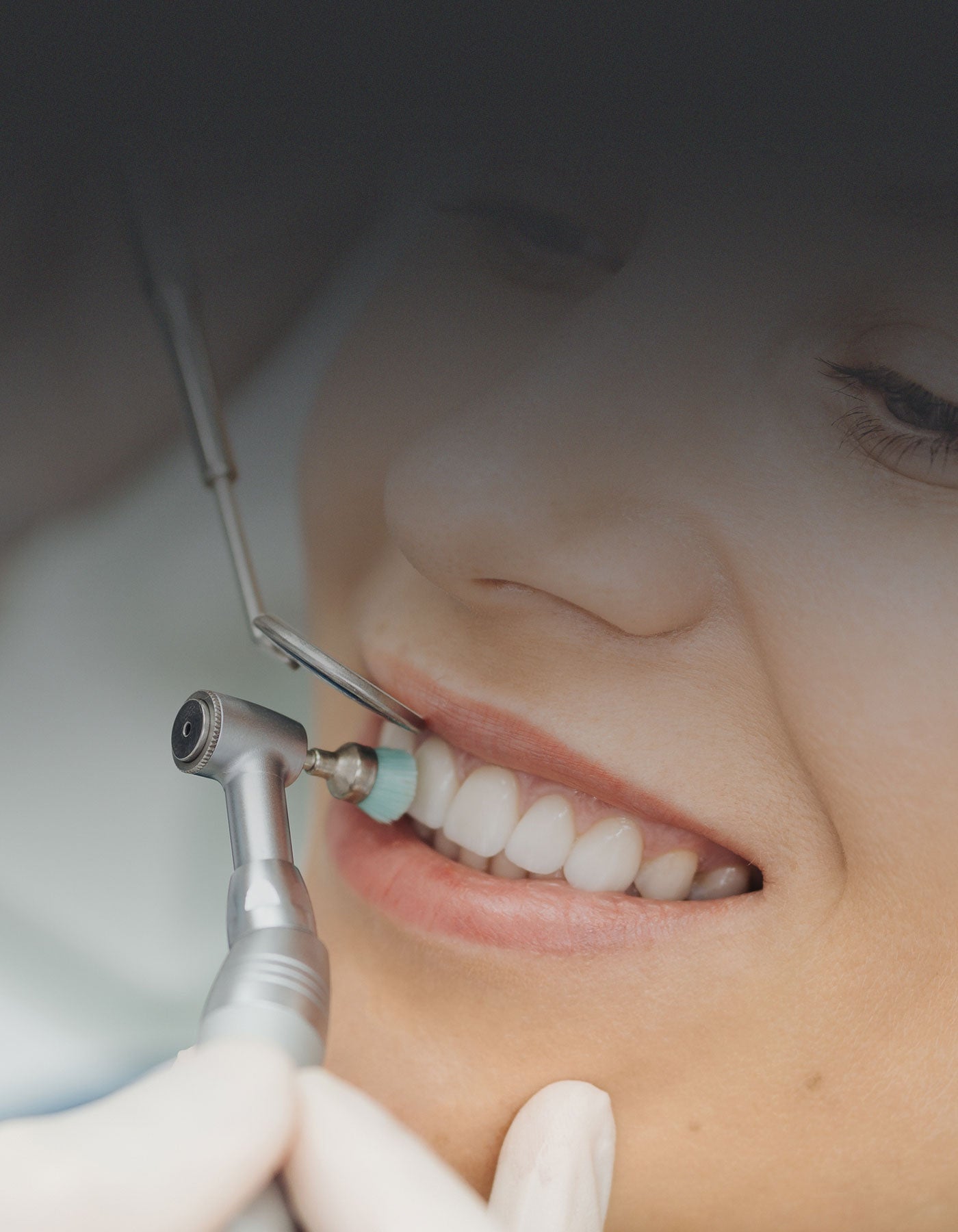 Patient having her teeth cleaned by dental hygienist
