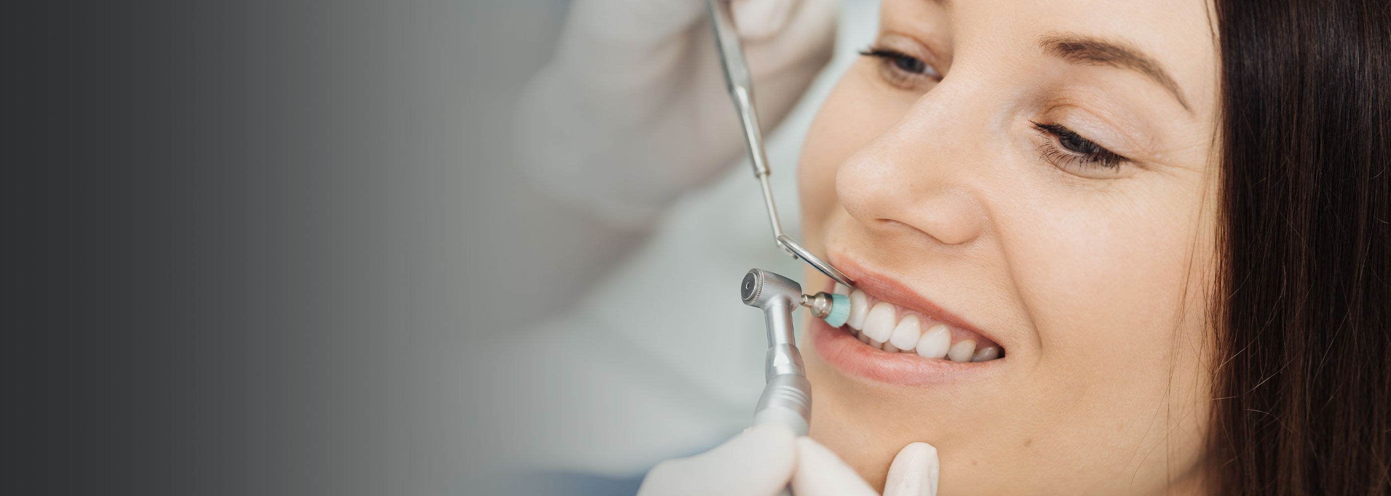 Patient having her teeth cleaned by dental hygienist
