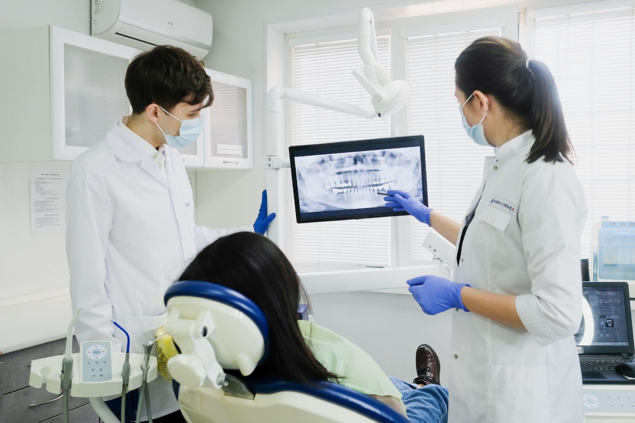 Cosmetic dentist with patient looking at x-ray